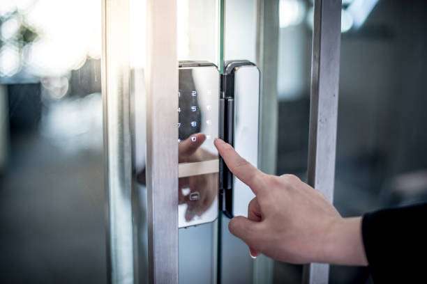 Businessman hand pressing down password number on electronic access control machine to open the office door. Security system concept